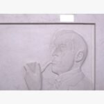 Hand-carved white marble bas-relief sculpture titled The Pipe Smoker by Julian Vance depicting a side profile portrait of a man holding and smoking a classic tobacco pipe.
