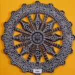 Hand-carved black stone relief wheel panel titled Dhammachakka Black Stone by Mangalya Stone Panels showcasing an intricate Dharma wheel with detailed decorative spokes and an ornate border.