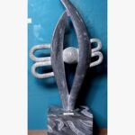 Hand-carved black stone sculpture titled Abstract Eye with Bindu by Mangalya Stone Panels showcasing a modern vertical eye silhouette enclosing a textured sphere and stylized background loops.
