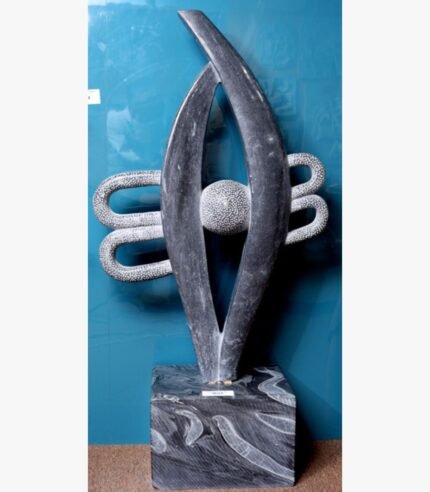 Hand-carved black stone sculpture titled Abstract Eye with Bindu by Mangalya Stone Panels showcasing a modern vertical eye silhouette enclosing a textured sphere and stylized background loops.
