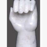A polished white marble hand sculpture shaped into a loose fist, showcasing intricate anatomical detailing and smooth stone textures against a neutral background.