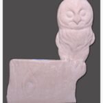 A hand-carved sandstone relief sculpture of an owl with detailed feathers perched on a rustic stone log ledge, showcased against a solid background.