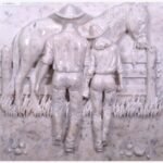 A hand-carved white marble relief panel depicting a cowboy and cowgirl holding hands by a wooden fence with a horse, showcasing intricate textures of western heritage art.