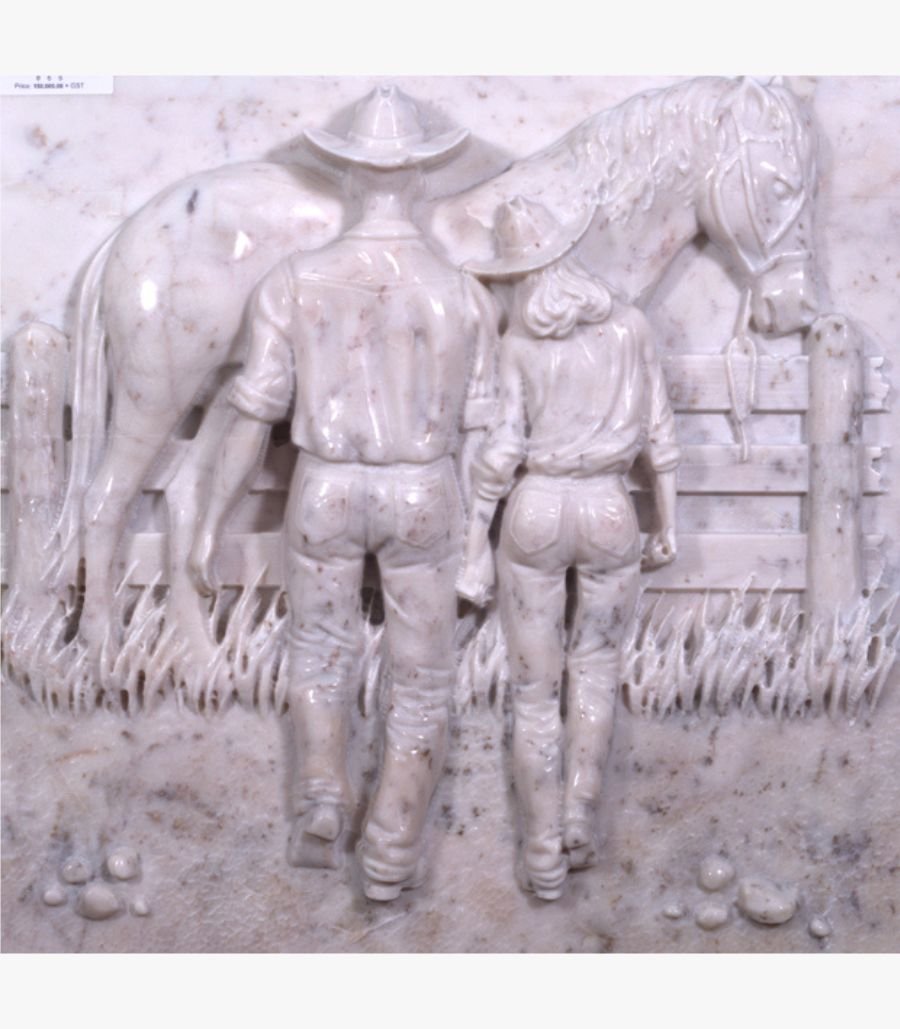 w A hand-carved white marble relief panel depicting a cowboy and cowgirl holding hands by a wooden fence with a horse, showcasing intricate textures of western heritage art.