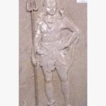 Hand-carved Dhrangadhra beige sandstone vertical relief panel titled Shivadev by Mangalya Stone Panels showcasing Lord Shiva standing with his trishul trident, a coiled cobra, and a tiger skin wrap.