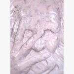 Hand-carved pink marble vertical relief panel titled Peeping Face by Mangalya Stone Panels depicting an expressive elder's face looking through chiseled fingers.