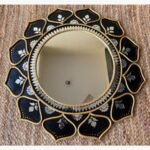 Traditional handcrafted round Lippan art wall mirror featuring black ceramic relief work, gold borders, and intricate glass mirror inlay by Rucha Desai.