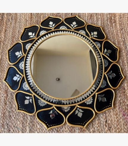 Traditional handcrafted round Lippan art wall mirror featuring black ceramic relief work, gold borders, and intricate glass mirror inlay by Rucha Desai.
