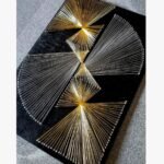 Modern 3D geometric string art featuring gold and silver thread fans on a textured black wooden board by Art Impression.