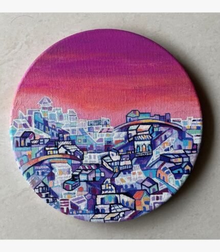 Circular acrylic painting titled The Warmth of Cityscape by Payal Dubey depicting a colourful architectural landscape under a twilight sky.